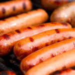 Close up of grilled hot dogs on grill.