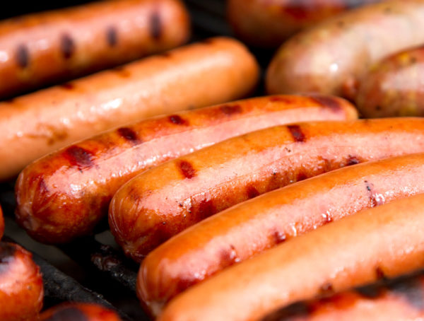 Close up of grilled hot dogs on grill.