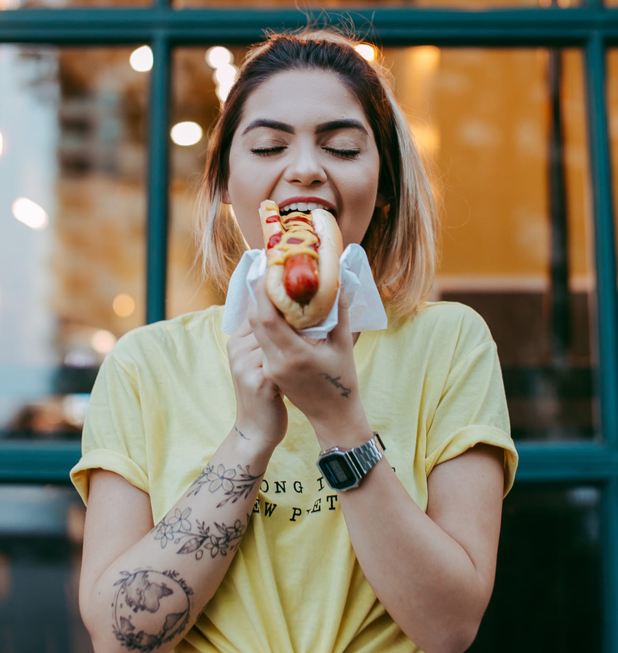 A photo of a woman eating a hot dog