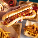 Hotdog sandwich on brown wooden table.